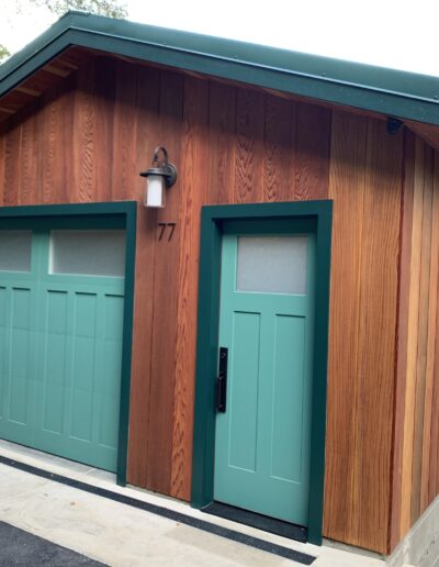 A garage with a blue door and green trim.