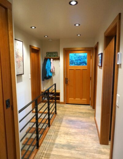 A hallway with wood floors and a coat rack.