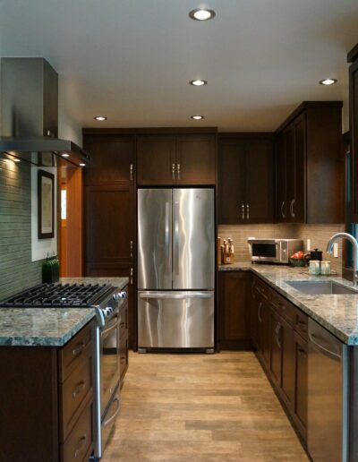 A kitchen with dark wood cabinets and stainless steel appliances.