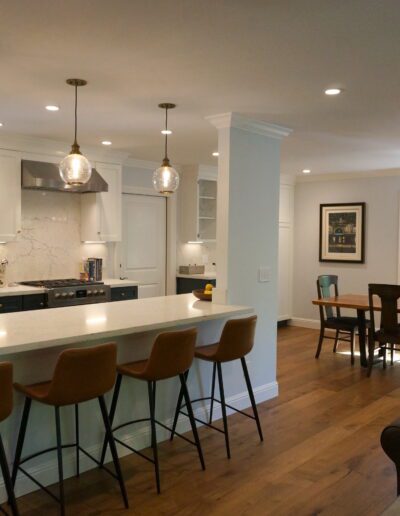 A kitchen with a dining area and bar stools.